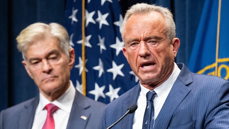 Robert F. Kennedy Jr. speaks while Mehmet Oz looks on during a news conference.