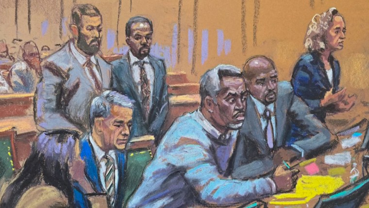 Sean Combs sits in court surrounded by people