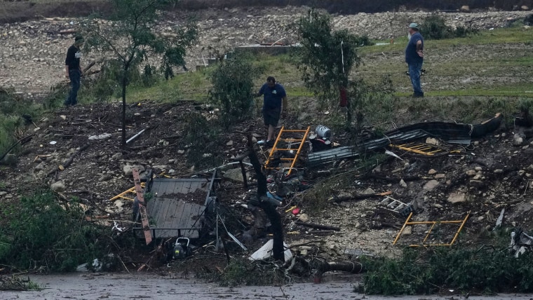Men survey damage left by a raging Guadalupe River