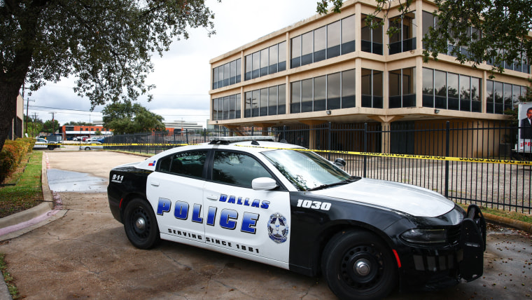 A Dallas police department car is parked in front of a building