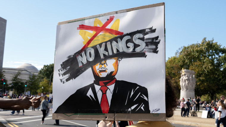A protester holds a "No Kings" sign at a rally during a national day of protest.