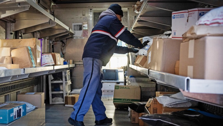 A USPS worker sorts packages in a vehicle on Cyber Monday in New York, US, on Monday, Dec. 1, 2025. 