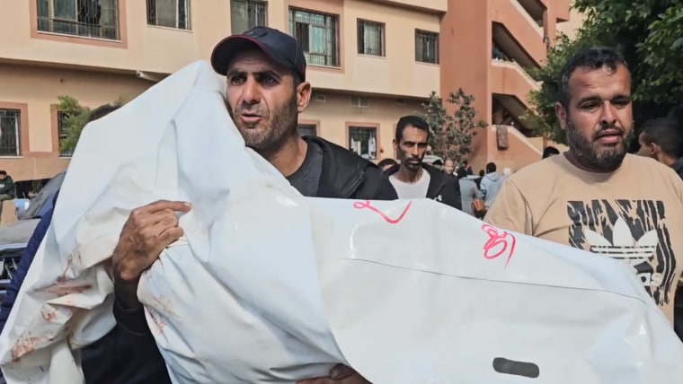 Rami Essam Abu Jamea and his family members cry while kneeling on the floor