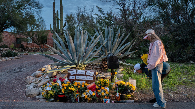 People stop at a makeshift memorial at the entrance to Nancy Guthrie's home on Feb. 12, 2026 in Tucson, Ariz.