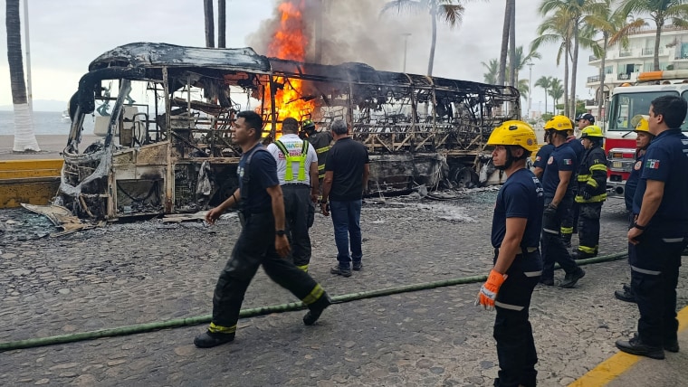 Firefighters work to extinguish flames from buses allegedly set on fire by members of organized crime in Puerto Vallarta, Mexico, on Feb. 22, 2026. 