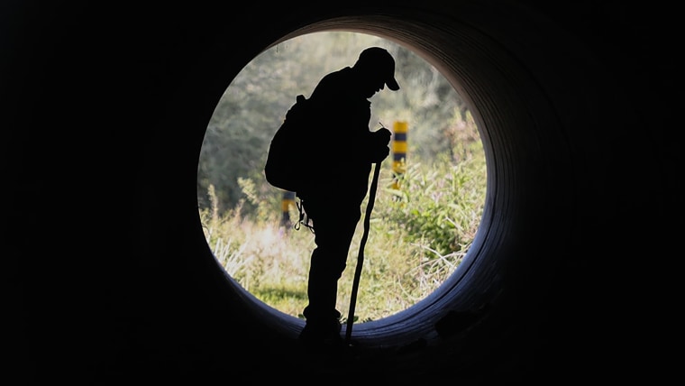 A volunteer searches a culvert near Nancy Guthrie's residence in Tucson on Sunday. While authorities believe Guthrie may have been taken from her home, no suspects or persons of interest have been publicly identified.