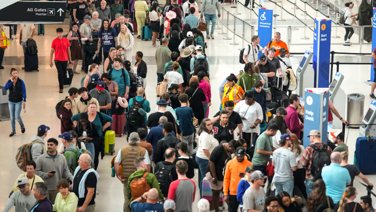 An elevated view of throngs of people in an airport terminal.