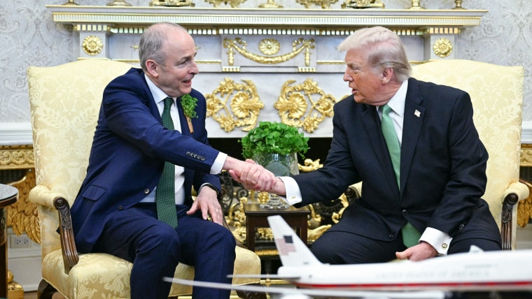 Micheal Martin, left, and Donald Trump shake hands while seated in the Oval Office of the White House