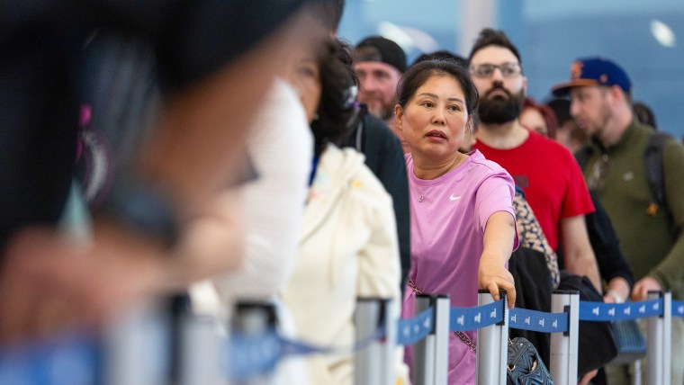 People wait in line for TSA.