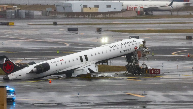 Image: An Air Canada Express CRJ-900 sits on the runway after colliding with a Port Authority fire truck 