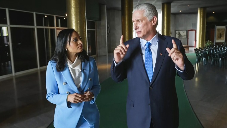 Kristen Welker and Miguel Díaz-Canel speak to each other while walking inside of a building