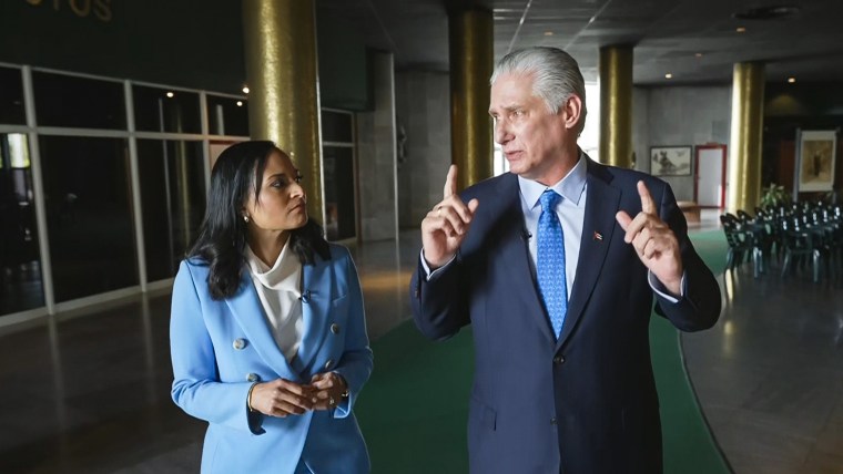 Kristen Welker and Miguel Díaz-Canel speak to each other while walking inside of a building