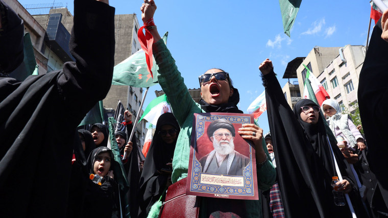 Iranians hold pictures of the late Iranian supreme leader Ayatollah Ali Khamenei 