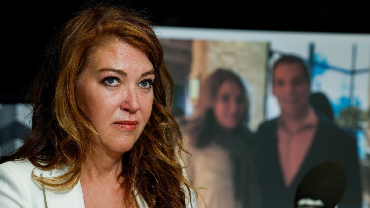 Lonna Drewes speaks at a news conference alongside a photo of her with Rep. Eric Swalwell on April 14, 2026 in Beverly Hills, Calif.