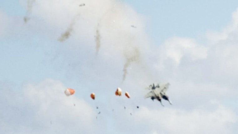 A blurred photo of four pilots parachuting from two fighter jets after a mid-air collision.