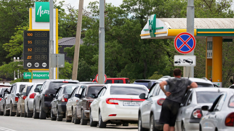 Cars queue for fuel at a gas station in Saki