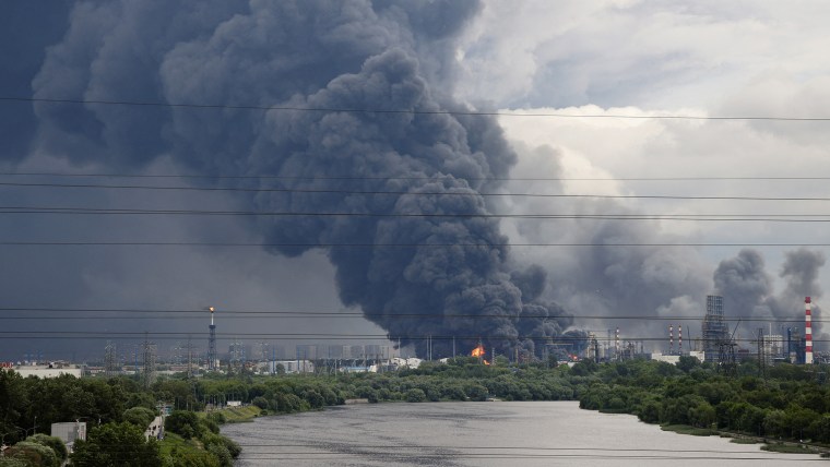 Thick plumes of smoke with flames rise from an oil refinery following a Ukrainian drone attack in Moscow