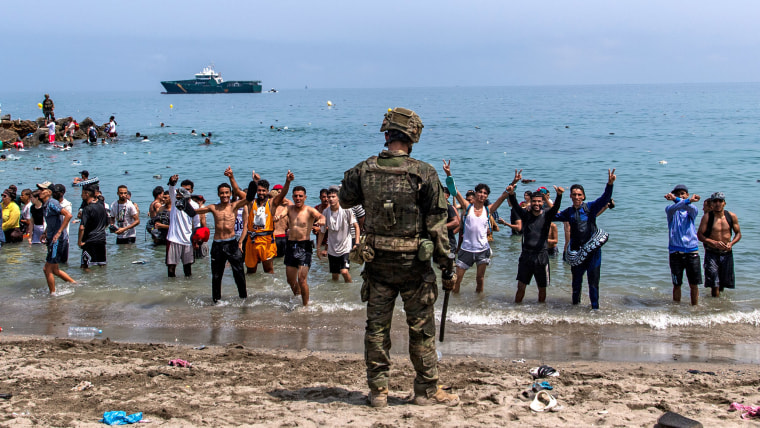 Spanish army soldiers block access to the beach for people crossing from Morocco into the Spanish enclave of Ceuta, Friday, July 31, 2026. 