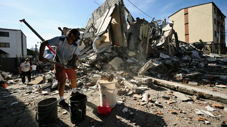 A man removes the debris of a collapsed house after an earthquake in Colombia.