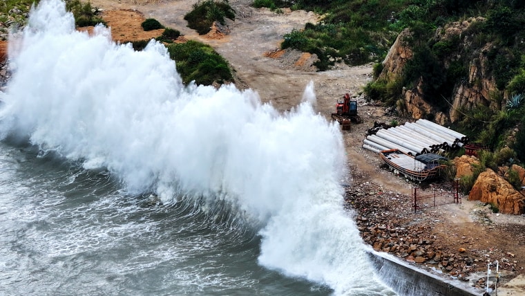 A huge wave crashes onto shore.