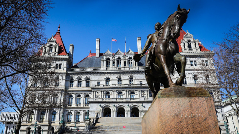 The Albany New York State Capital Building exterior, with a statue of a man riding a horse on a pedestal in front, the name Sheridan is engraved on the front of the pedestal