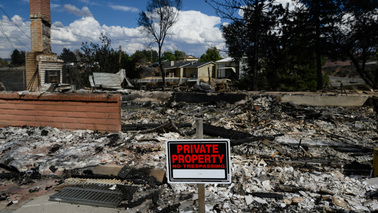 A burned home smolders after it was destroyed by fires.