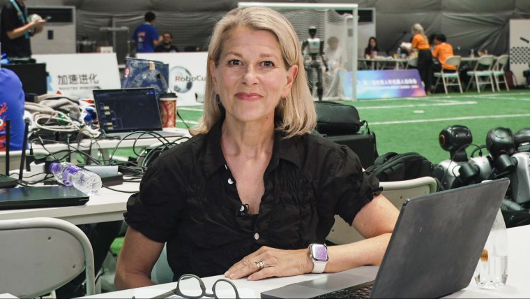 Janis Mackey Frayer smiles while seated at a table in front of her laptop