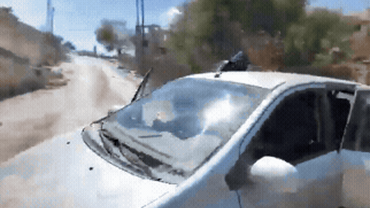 Masked attackers hit a car window as the car tries to escape and then an attacker hits the camera person