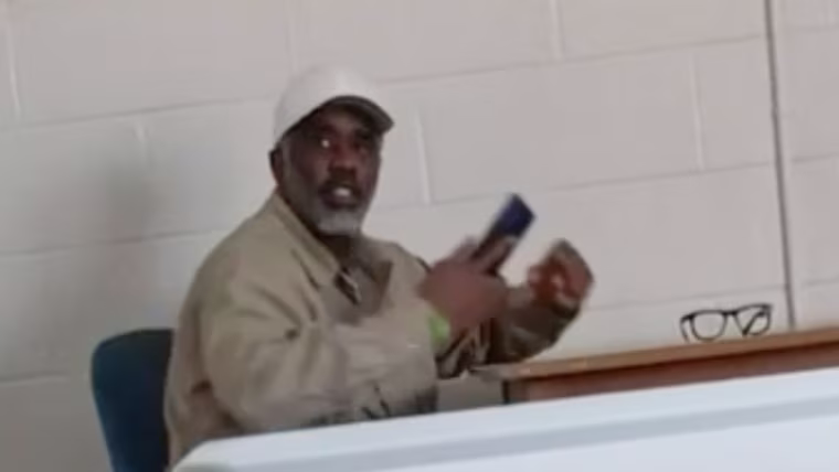 Diddy seated at a table holding a cellphone