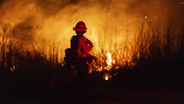 A firefighter monitors the spread of fire.