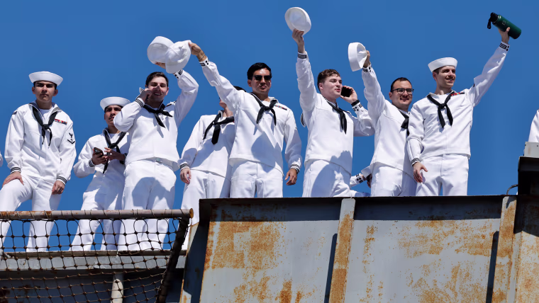 Sailors wave from a boat
