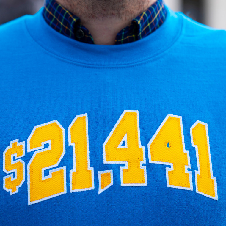 Cody Hounanian, executive director at the Student Debt Crisis Center, in a sweatshirt with the amount he owed in student loans  during a protest in support of student debt cancellation as the Supreme Court begins oral arguments on Feb. 28, 2023.