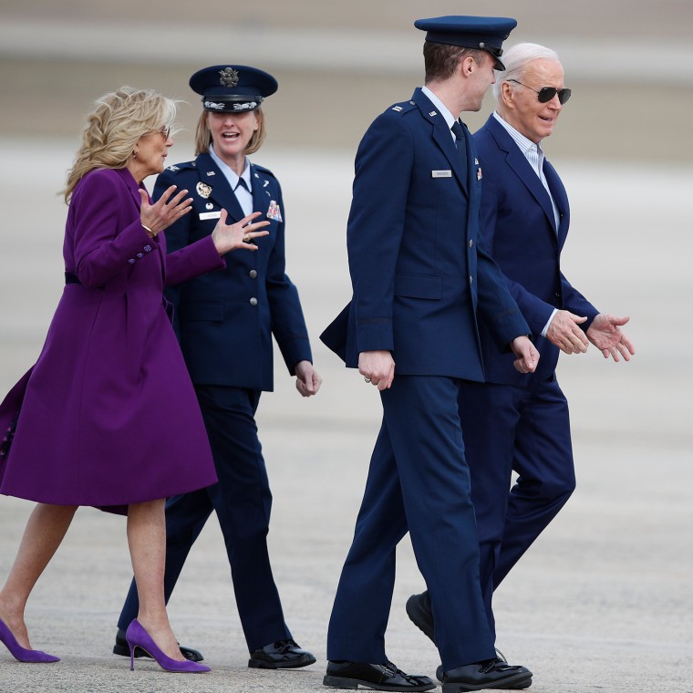 President Joe Biden, right, is escorted by Air Force Cpt. Eric Anderson, 89th Airlift Wing Flightline protocol officer, as first lady Jill Biden, left, talks to Col. Angela Ochoa, commander of the 89th Airlift Wing,