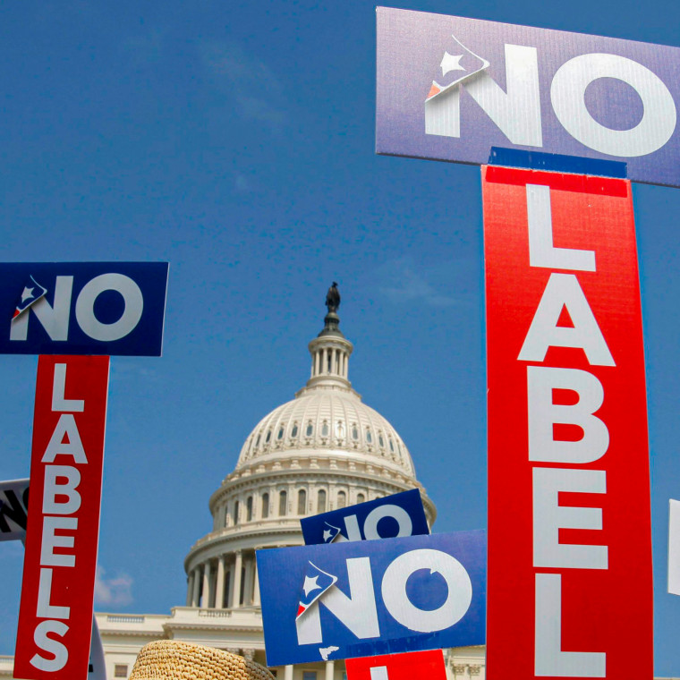 People with the group No Labels hold signs during a rally.