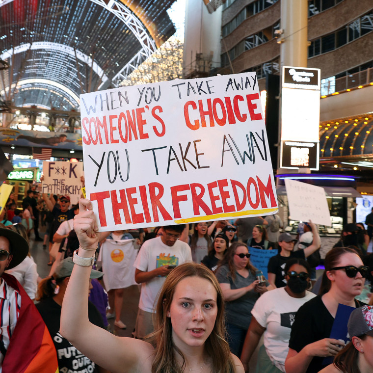 Abortion rights activists march along Fremont Street Experience.