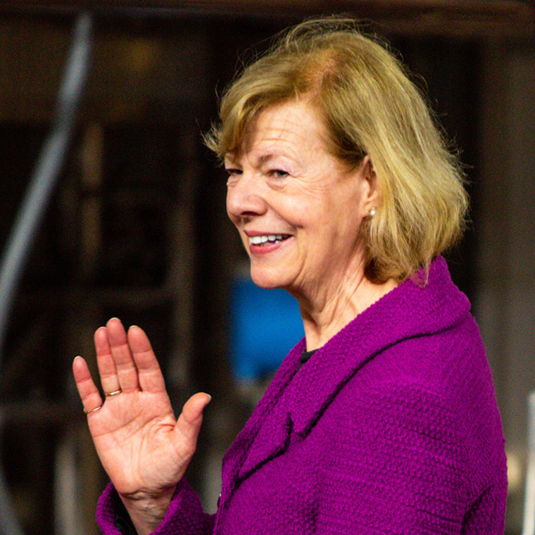 Tammy Baldwin waves as she walks off stage after speaking