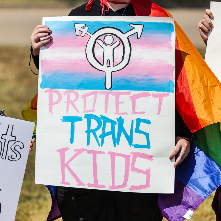 A protester's sign reads, ''protect trans kids'' at a demonstration