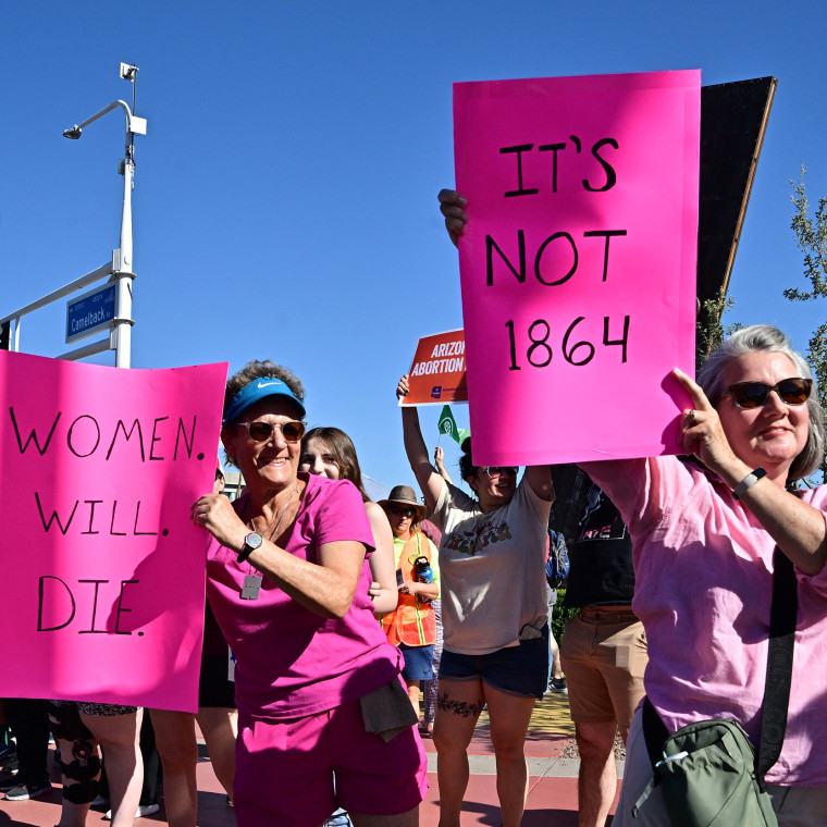 Demonstrators hold signs that read "Women Will Die" and "It's not 1864"