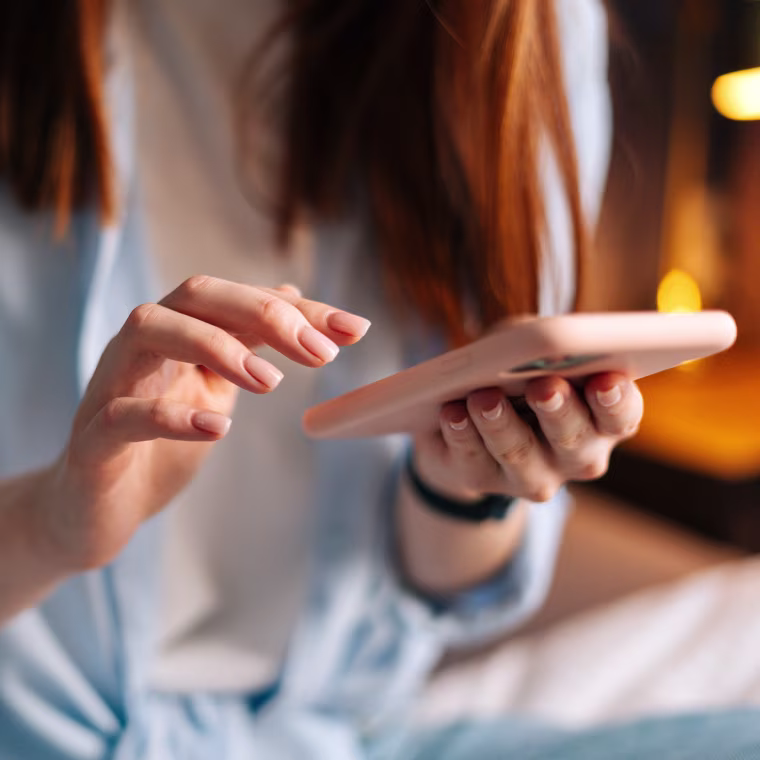 Close-up of unrecognizable woman texting message on mobile cellphone and chatting on social online.