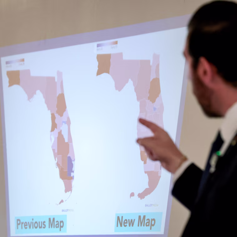 Oliver Larkin, Democratic candidate for Congress in Florida’s 23rd district, speaks during an emergency town hall that he held to address Florida Republicans’ newly approved congressional redistricting map (seen on wall).