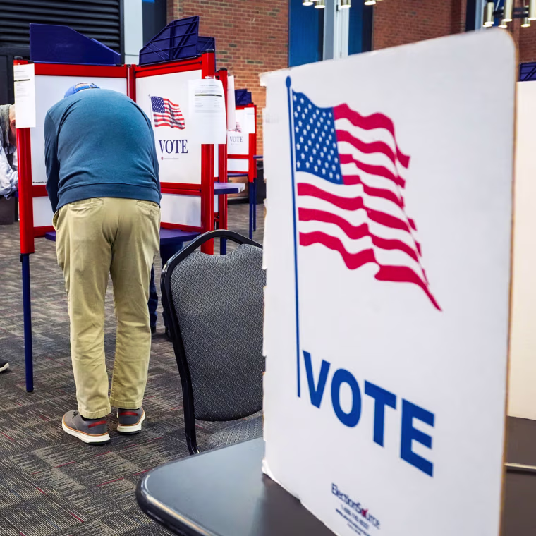 People vote at voting booths inside of a room