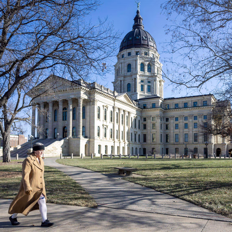 A person walks by The Kansas State Capitol outside
