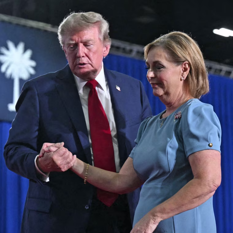 President Donald Trump helps Sen. Darline Graham off the stage during a campaign rally in Myrtle Beach, S.C., on Aug. 21, 2026. 