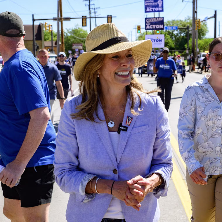 Amy Acton walking in a parade flanked by staffers.