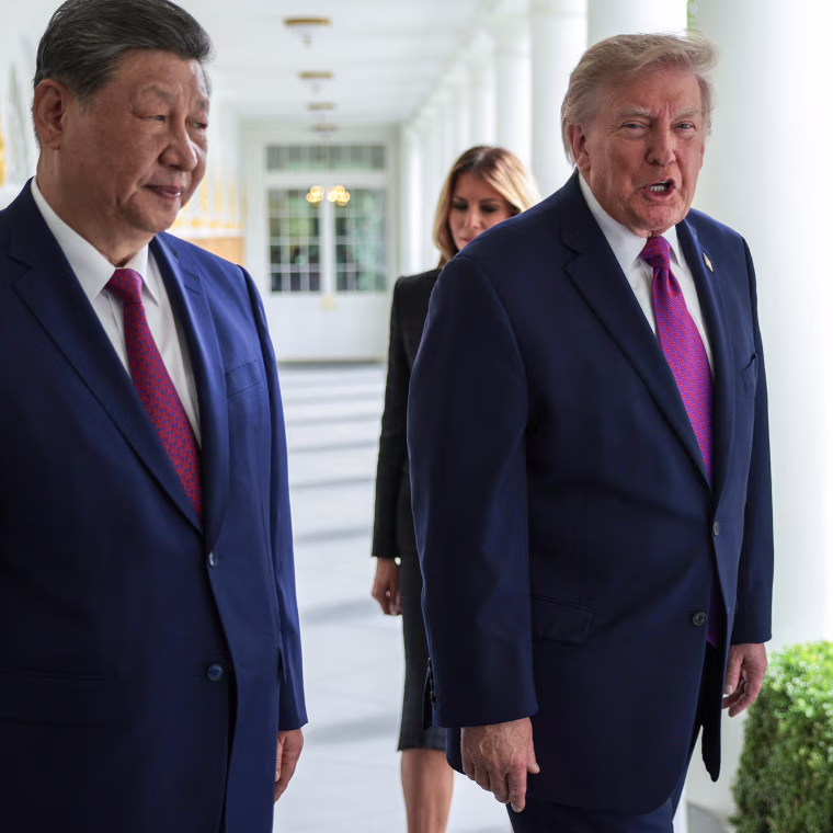 President Trump and President Xi Jinping walking along the White House colonade with their wives behind them.