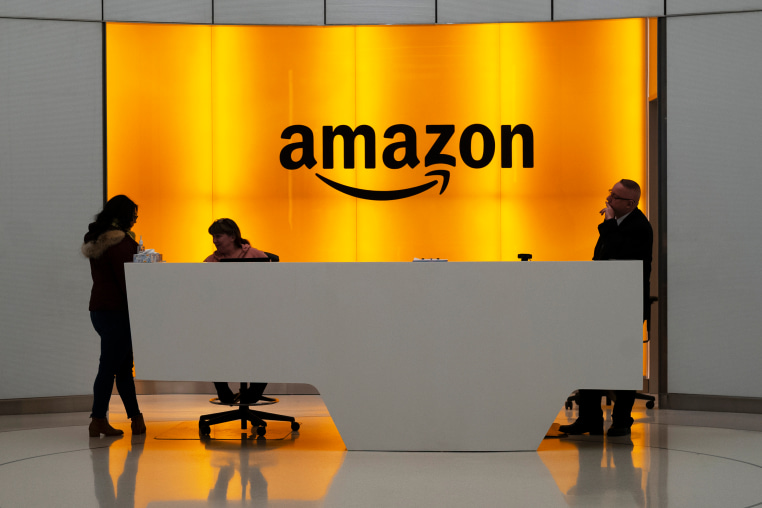 People stand in the lobby for Amazon offices in New York on Feb. 14, 2019.