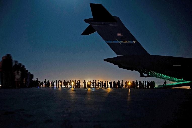 Evacuees board a U.S. Air Force C-17 Globemaster III at Hamid Karzai International Airport in Kabul, Afghanistan, on Aug. 20, 2021.