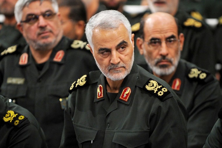 Qassem Soleimani, center, sits and looks on