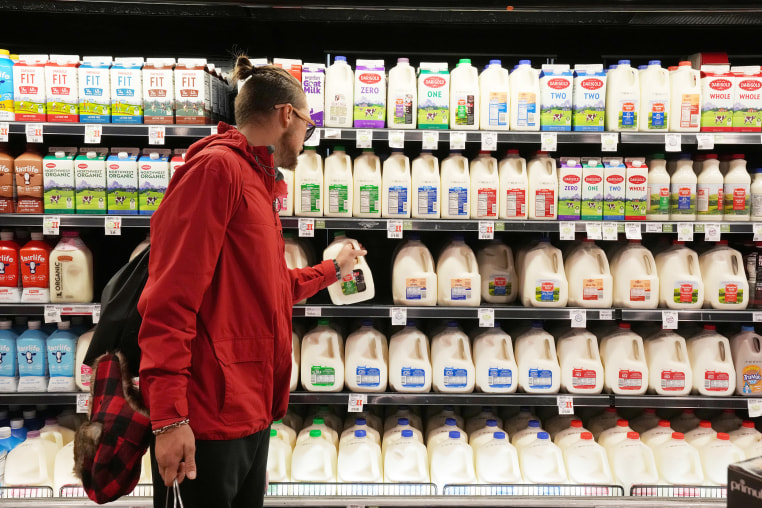 A customer takes a gallon of milk from a  store shelf in Salt Lake City,