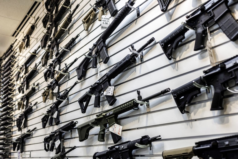 A selection of AR-15-style rifles hangs on a wall at R-Guns store on Jan. 11, 2023, in Carpentersville, Ill.